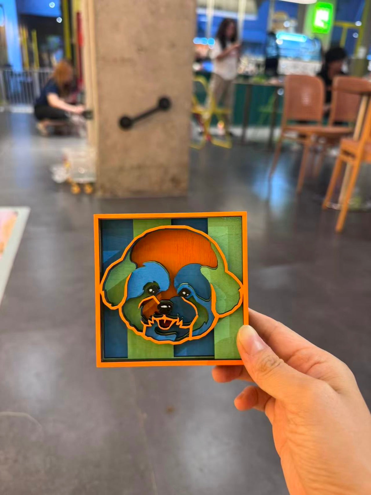 Hand holding a meadow color portrait in a cafe